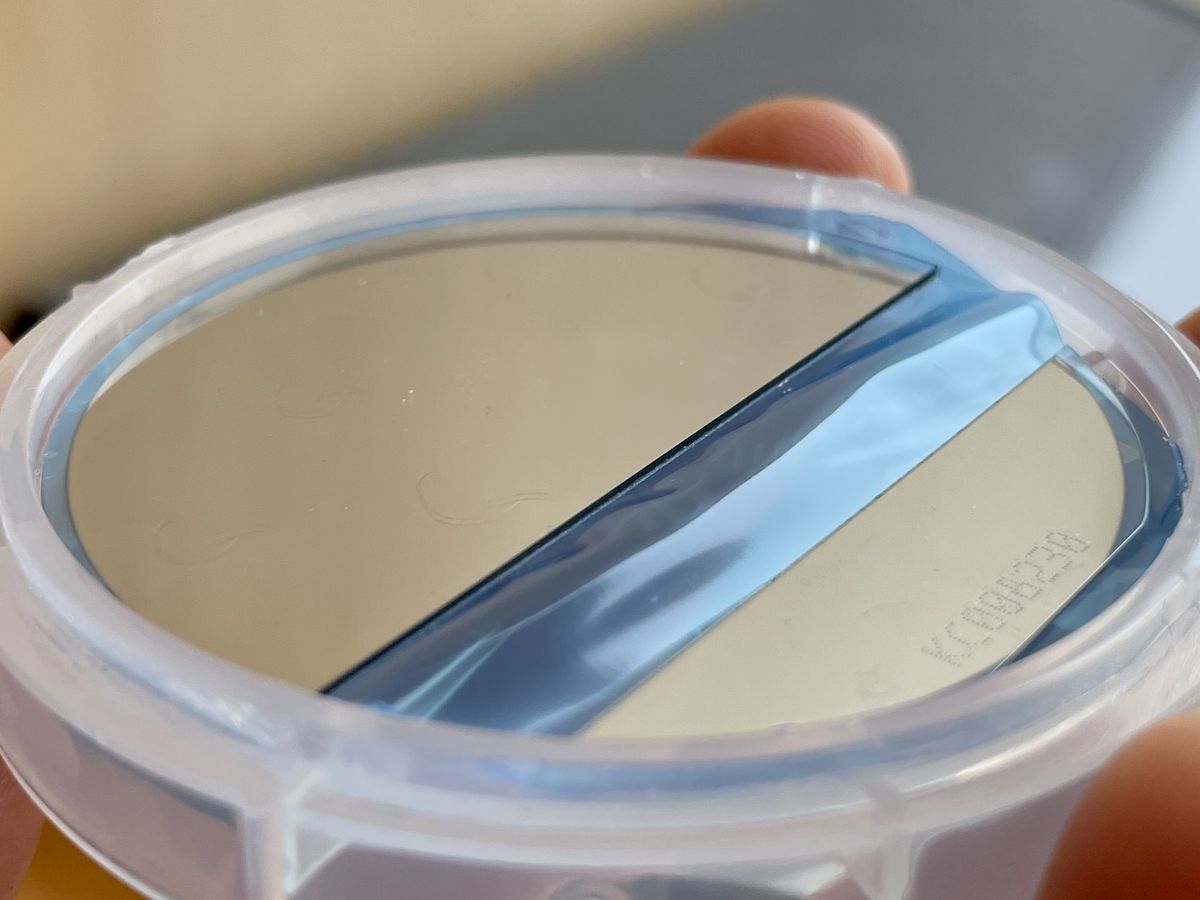 A film-coated sapphire wafer held in a single-wafer carrier